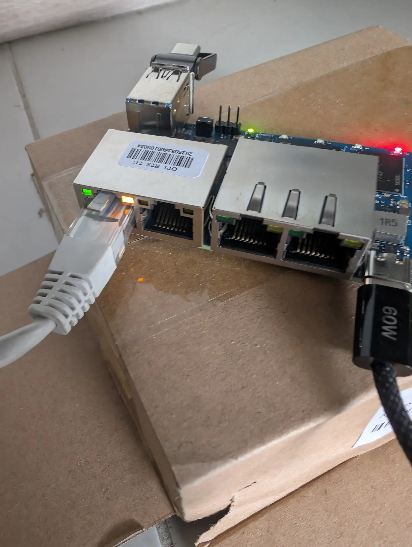 Fase 2: Orange Pi R2S gravando eMMC — LED vermelho, LED verde da placa e dois LEDs de Ethernet (verde + ambar) visiveis